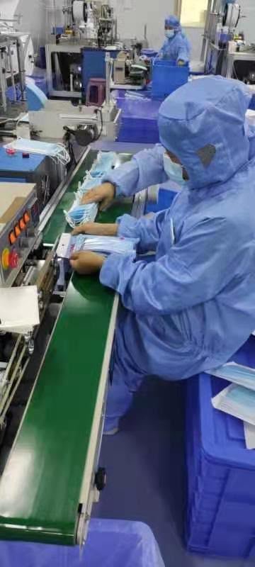 I-TEC staff member operating production line equipment in cleanroom attire
